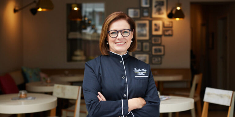 Portrait von Isabella vor einer Pâtisserie
